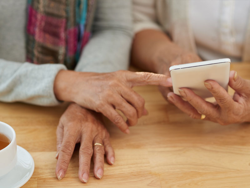 closeup of two female hands looking at a phone