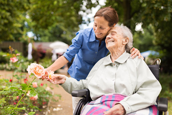 senior woman sitting on a wheelchair with caregiver