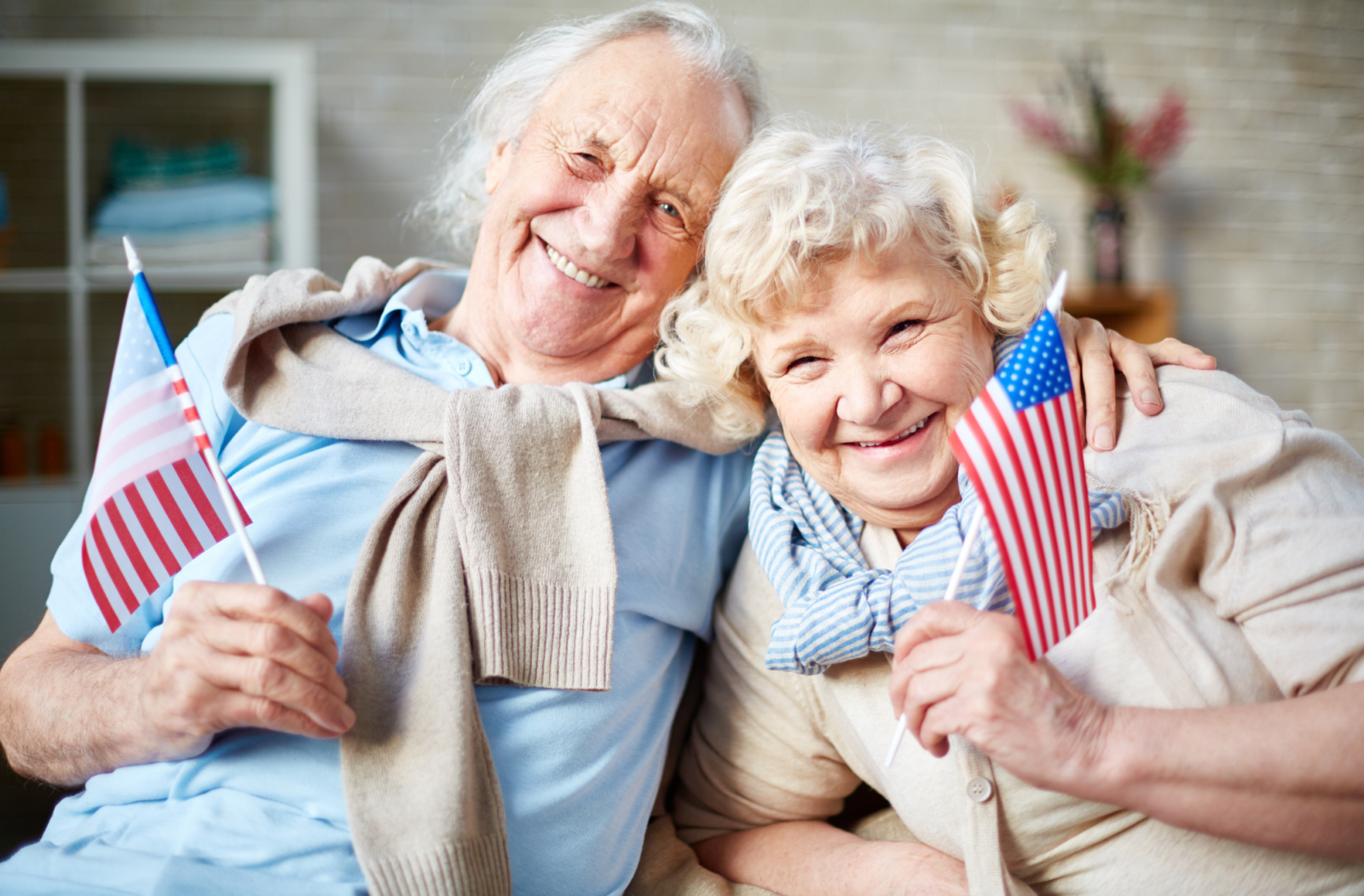 two elderly adults with american flags