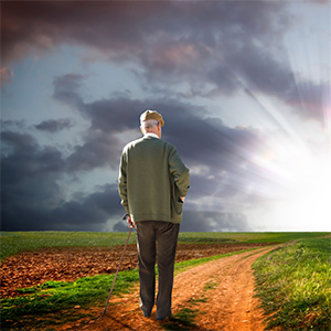 a senior man walking down a dirt path